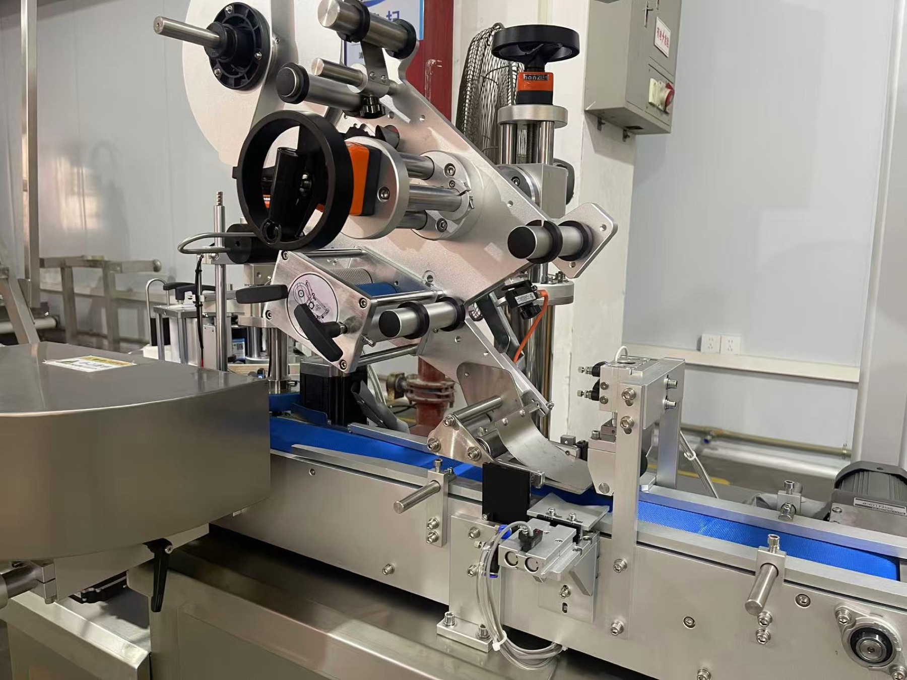 Label feed rollers and dispensing mechanism on a can labelling machine